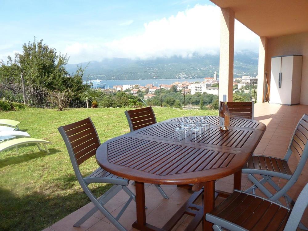 un tavolo e sedie in legno su un patio di T3 en rdj pour 6 pers dans résidence avec piscine a Propriano