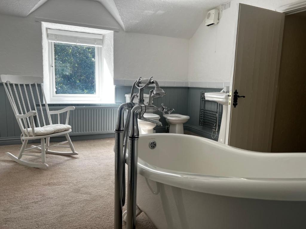 a bathroom with a tub and a chair in it at Old Mill Retreat, by River/Sea/Country Nr Barmouth Dogs in Talybont