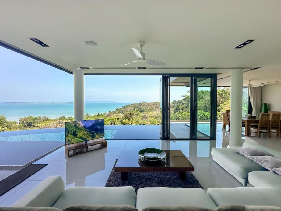 Ban Bang LaにあるCape Height 4-bedroom Seaview Luxury Pool Villaのソファとテーブルのあるリビングルーム