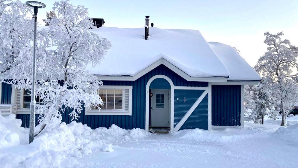 uma casa azul com neve em cima em Arctica em Saariselka