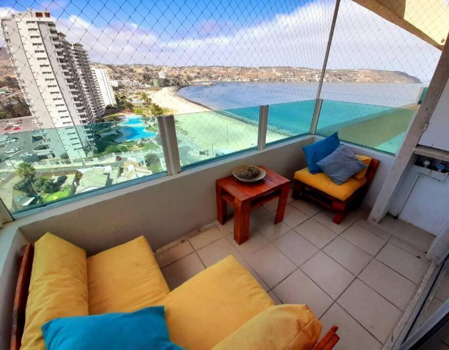 a balcony with a couch and a view of the ocean at Condominio Don Lorenzo in Coquimbo