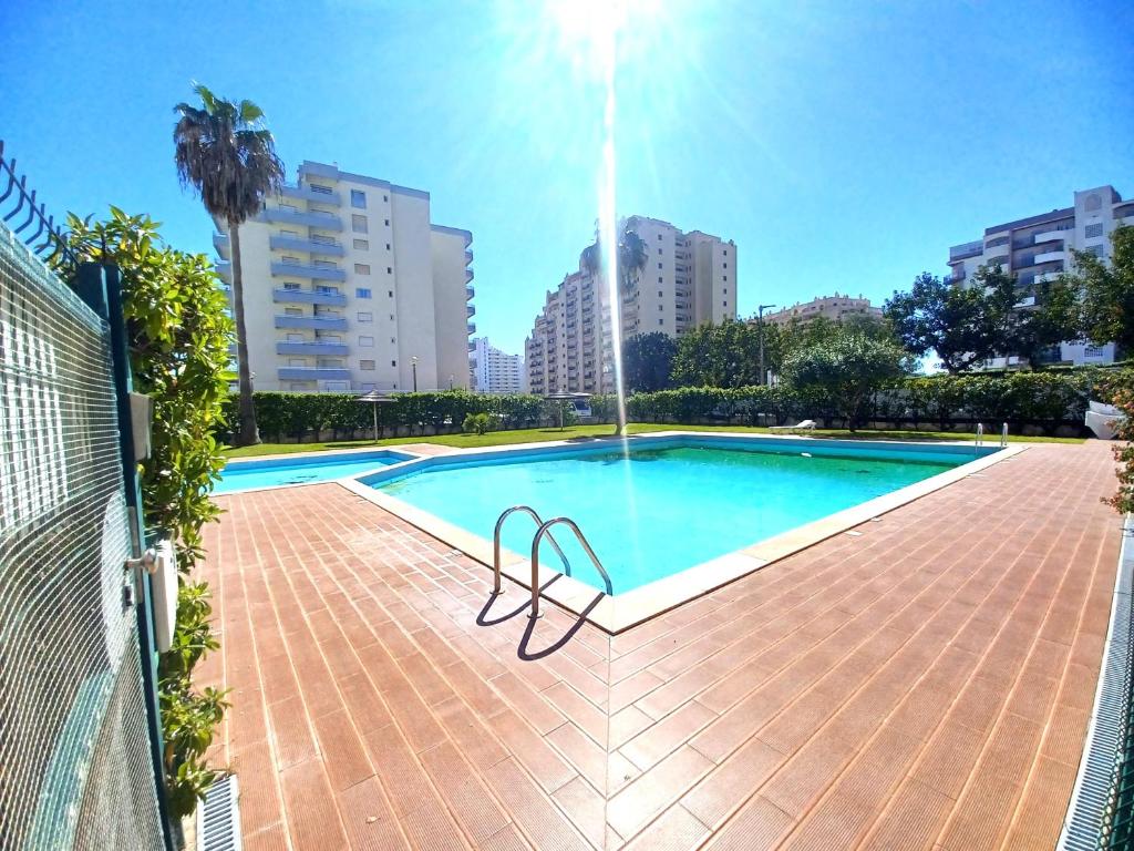 uma piscina com uma fonte numa cidade em Pink Beach Apartment 223 em Portimão