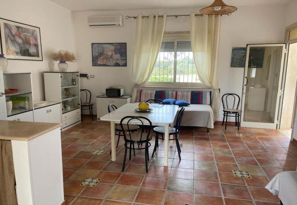 a kitchen and living room with a table and chairs at Villetta Greco - Torre Lapillo in Porto Cesareo