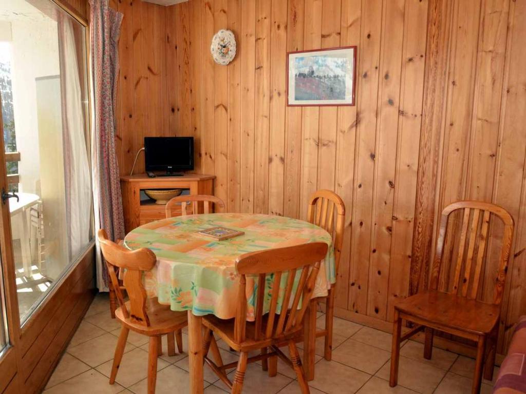 jadalnia ze stołem, krzesłami i telewizorem w obiekcie Studio lumineux au centre de Flaine avec balcon et kitchenette - FR-1-425-152 w mieście Flaine