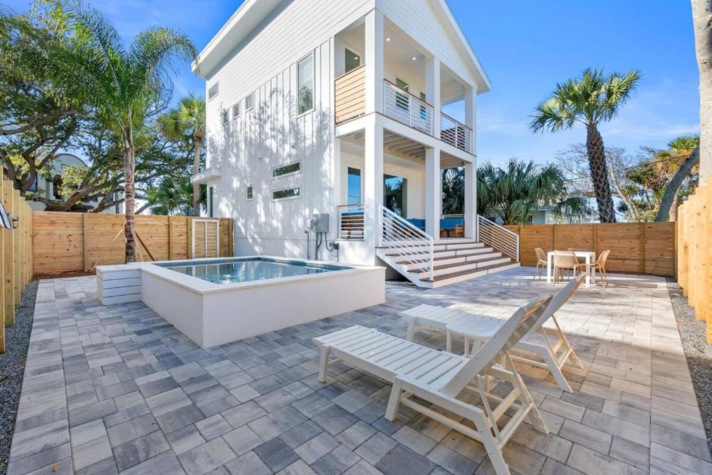 a white house with a swimming pool and a patio at Sunset Cove 2 - Heated Pool - Sea Views - Walkable in Saint Augustine