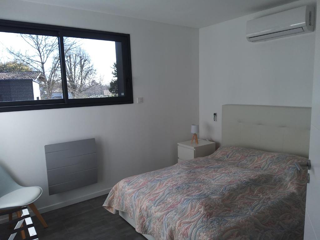 1 dormitorio con cama y ventana en Maison d’hôte neuve : T2 pour 4 voyageurs, en Mios