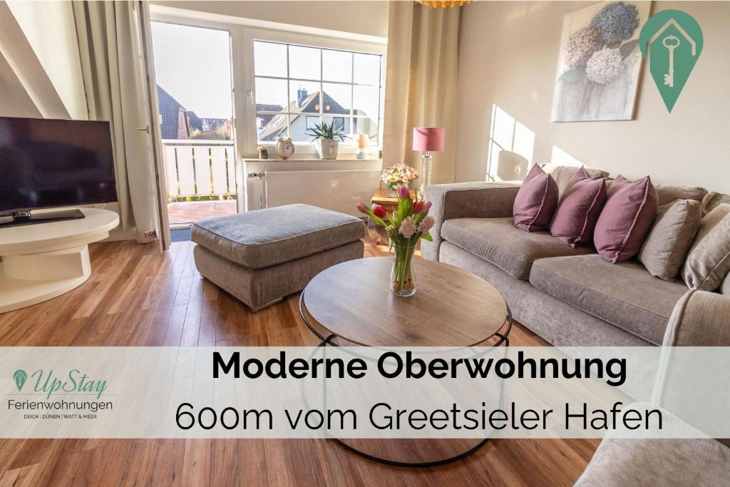 een woonkamer met een bank en een tafel bij Haus Hamburg OG in Greetsiel