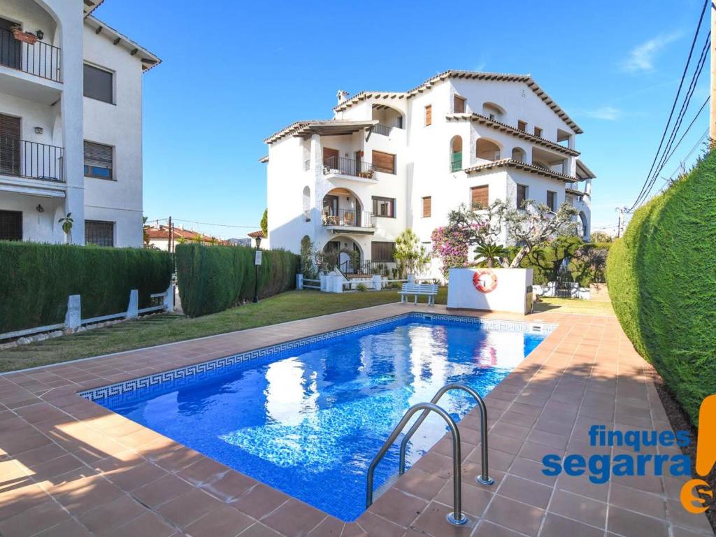 une villa avec une piscine en face d'un bâtiment dans l'établissement Apartamento Roda de Berà, 3 dormitorios, 6 personas - ES-320-2, à Roda de Bará