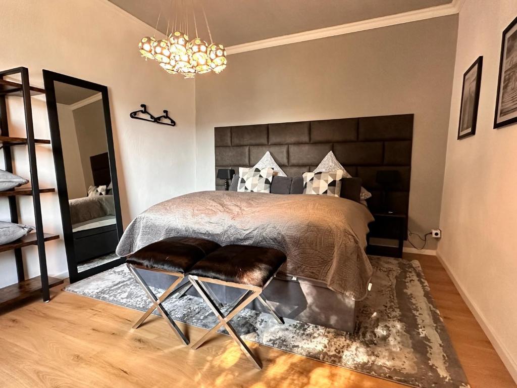 Schlafzimmer mit einem Bett und einem Kronleuchter in der Unterkunft 80qm Luxus Apartment mit großer Terrasse in Saarbrücken