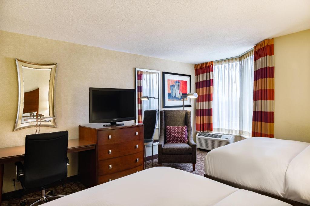 a hotel room with a bed and a desk with a television at DoubleTree by Hilton Johnson City in Johnson City
