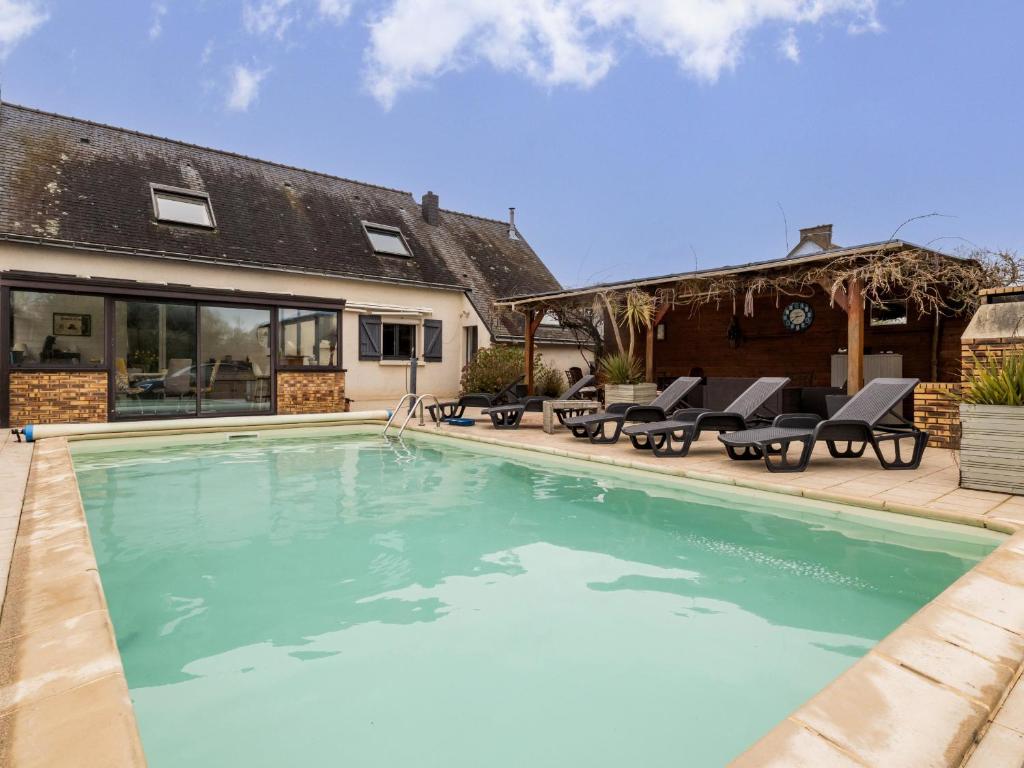 a swimming pool with chairs and a house at Gîte Saint-Molf, 6 pièces, 10 personnes - FR-1-306-1266 in Saint-Molf