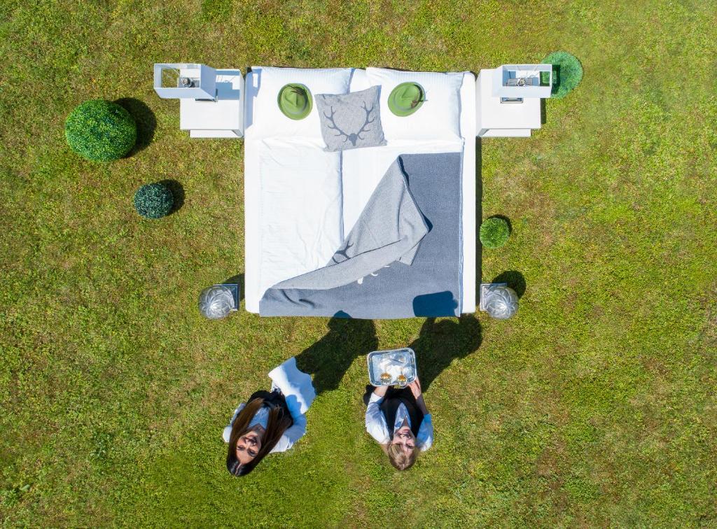zwei Leute stehen neben einem Tisch im Gras in der Unterkunft Hotel Hubertus in Söchau