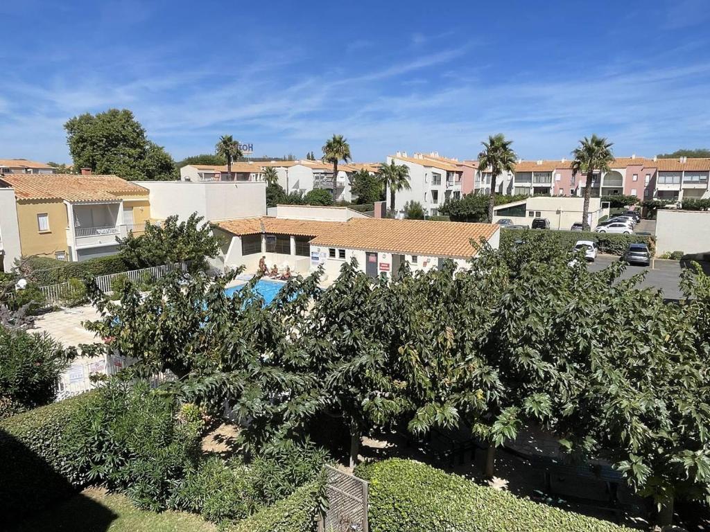 - une vue sur une ville avec des arbres et des maisons dans l'établissement Appartement 4 pers, piscine, parking, climatisé, proche plage, salle de sport et commodités - FR-1-723-136, au Cap d'Agde