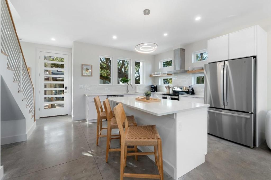 eine weiße Küche mit einer Insel mit Stühlen und einem Kühlschrank in der Unterkunft Sunset Cove - Heated Pool - Sea Views - Walkable in St. Augustine