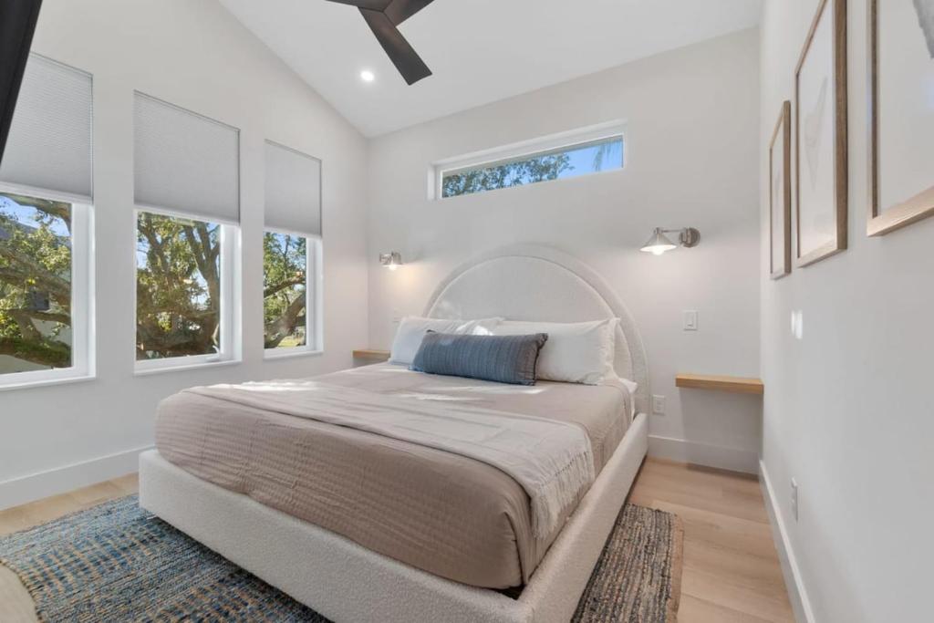 ein weißes Schlafzimmer mit großem Bett und Fenstern in der Unterkunft Sunset Cove - Heated Pool - Sea Views - Walkable in St. Augustine