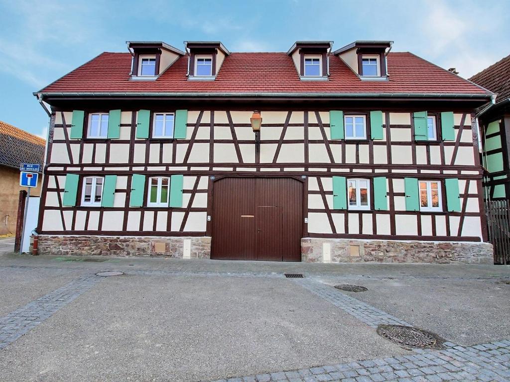 une grande maison avec une porte marron et un toit rouge dans l'établissement Maison Geispolsheim, 5 pièces, 8 personnes - FR-1-722-5, à Geispolsheim
