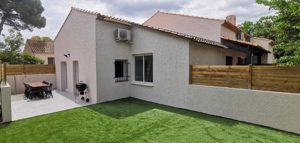 a house with a yard with a green lawn at Sea Sun and Thau in Marseillan