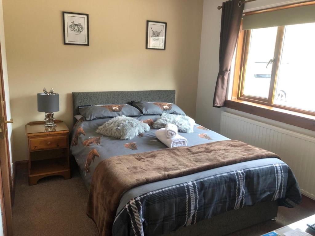 a bedroom with a bed with two stuffed animals on it at The Woolly Rock in North Ballachulish
