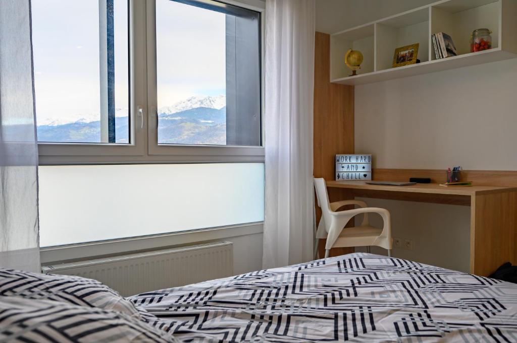 1 dormitorio con cama, escritorio y ventana en Nemea Gières, en Gières