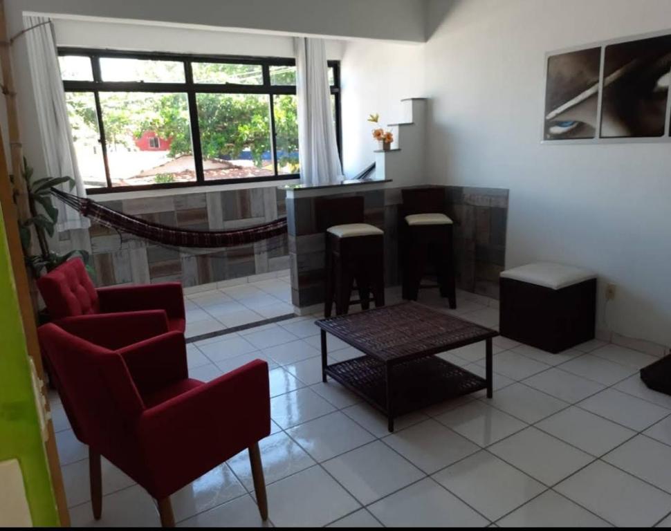 sala de estar con sillas rojas y mesa en Residence Sonho Azul, en Salvador
