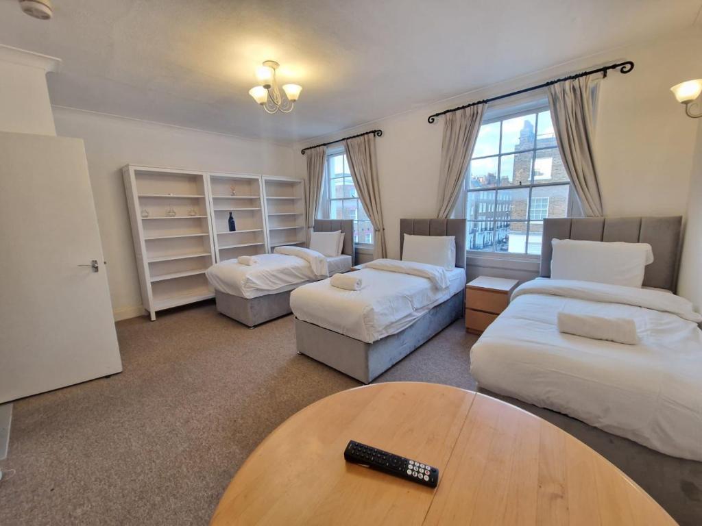 a living room with two beds and a table at Baker Street Suites in London