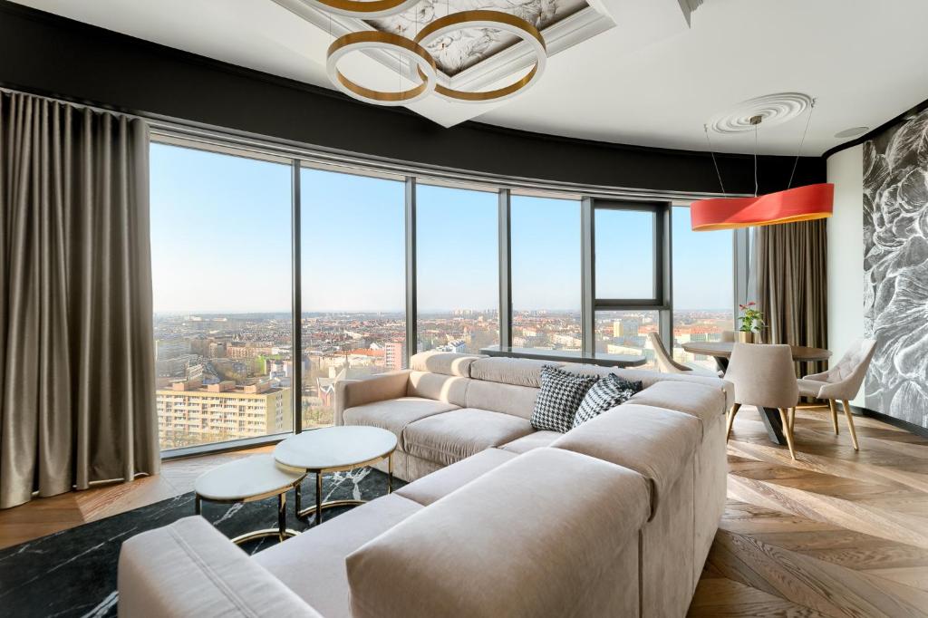 ein Wohnzimmer mit Sofa und vielen Fenstern in der Unterkunft Margi Dali Apartament PRESTIGE LUX HANZA TOWER in Stettin