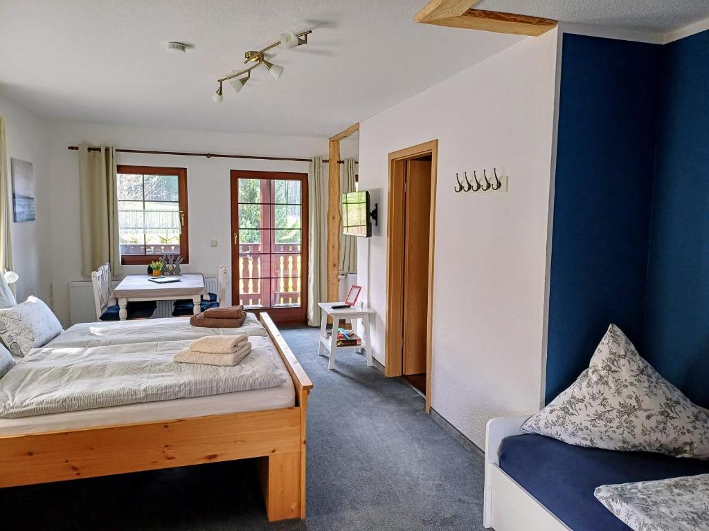 1 dormitorio con cama y pared azul en Ferienwohnungen 1 bis 4 "Pumphut's Scheune" en Lengenfeld