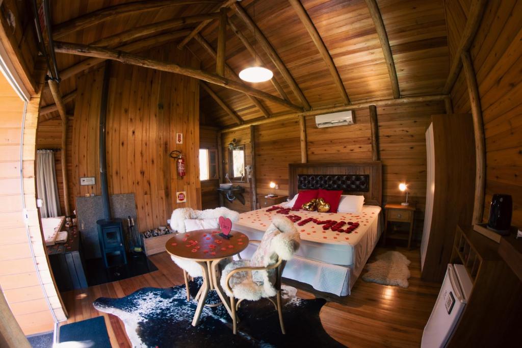 1 dormitorio con 1 cama, mesa y sillas en Hospedaria Refugio do Invernador en Urubici