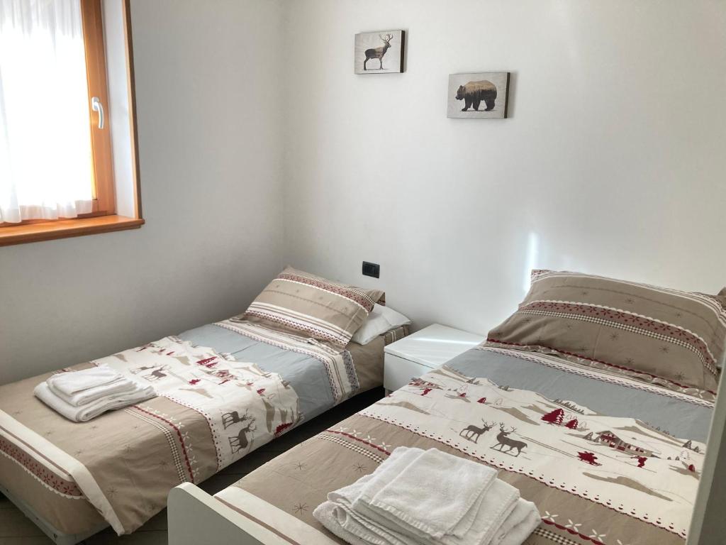 sypialnia z dwoma łóżkami i oknem w obiekcie Adamello Brenta Sunshine w Madonna di Campiglio