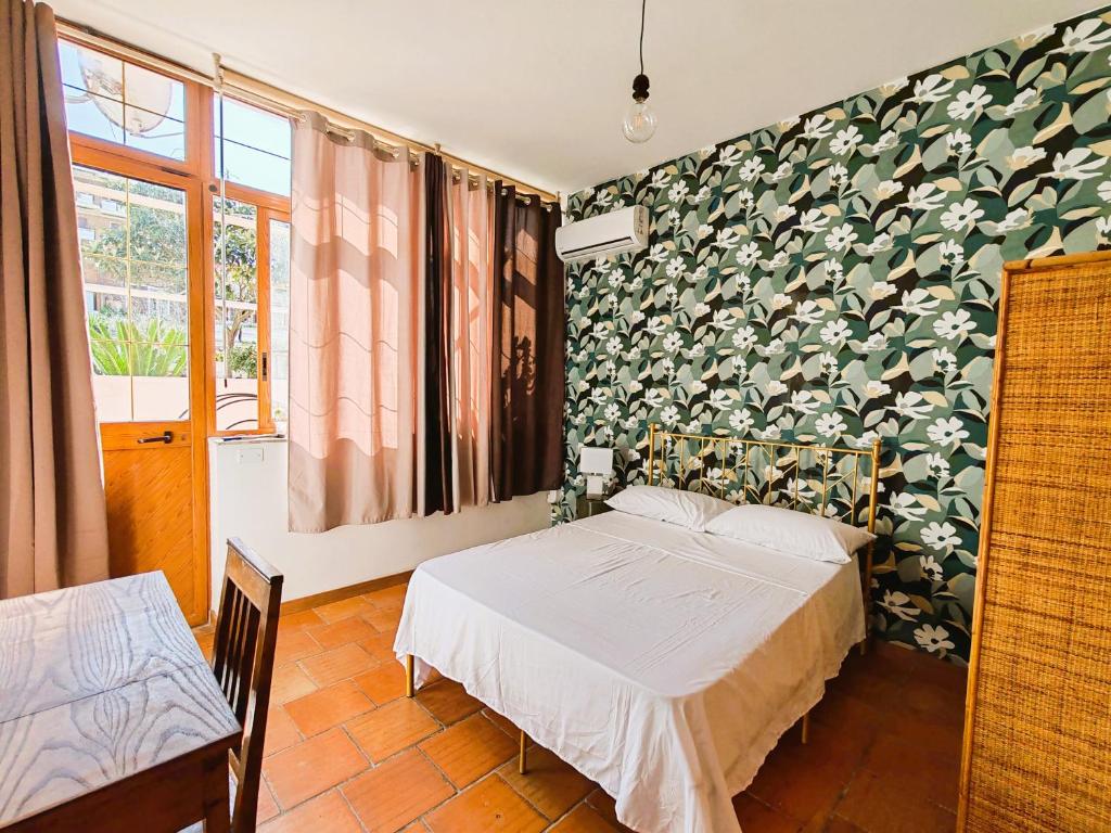 een slaapkamer met een bed en een muur bedekt met bladeren bij OSTIA HOME in Lido di Ostia