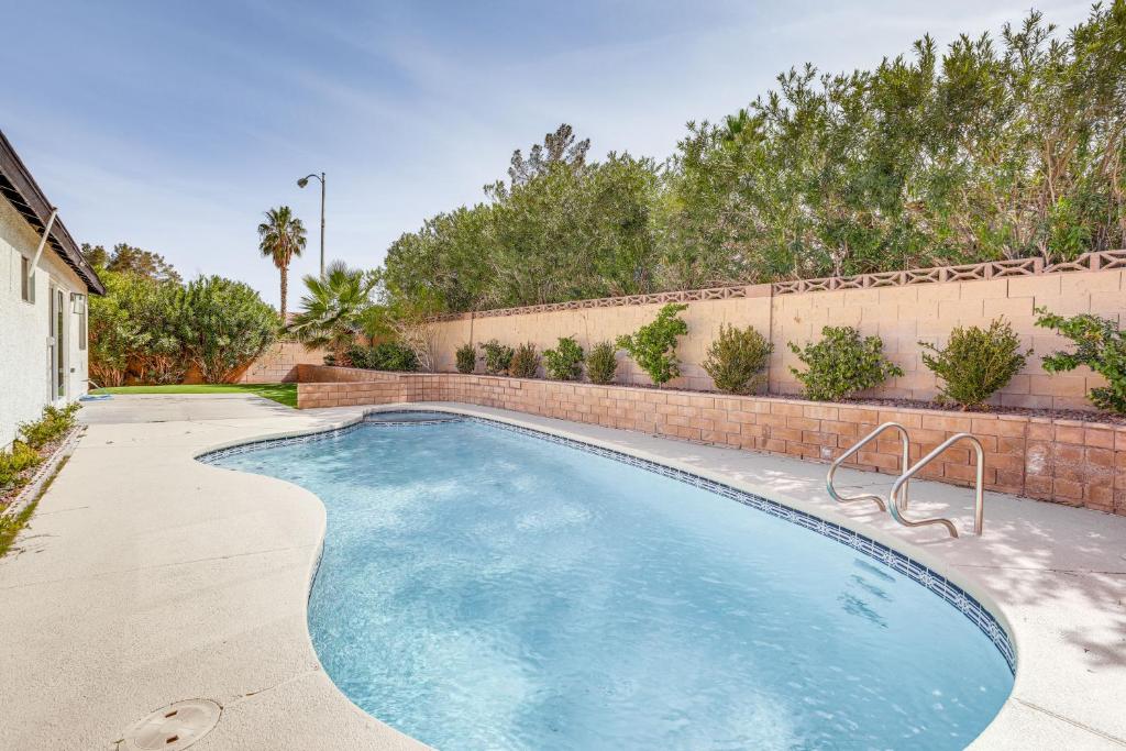 een zwembad in een tuin met een bakstenen muur bij Las Vegas Home with Pool about 4 Mi to Las Vegas Strip! in Las Vegas
