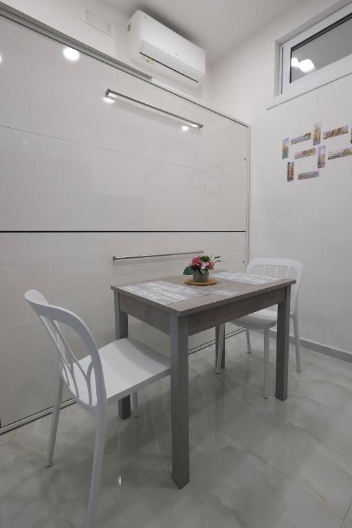 einen Tisch und Stühle in einem weißen Zimmer in der Unterkunft Sun In Naples - Tribunali in Neapel