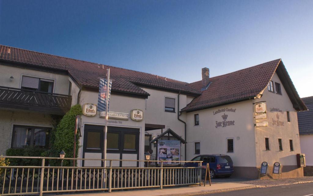 ein weißes Gebäude mit einer Flagge davor in der Unterkunft Landhotel Gasthof Zur Krone in Leidersbach