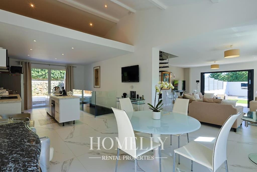 une cuisine et un salon avec une table et des chaises blanches dans l'établissement Villa élégante avec piscine à Saint-Tropez - Villa Chrystal, à Saint-Tropez