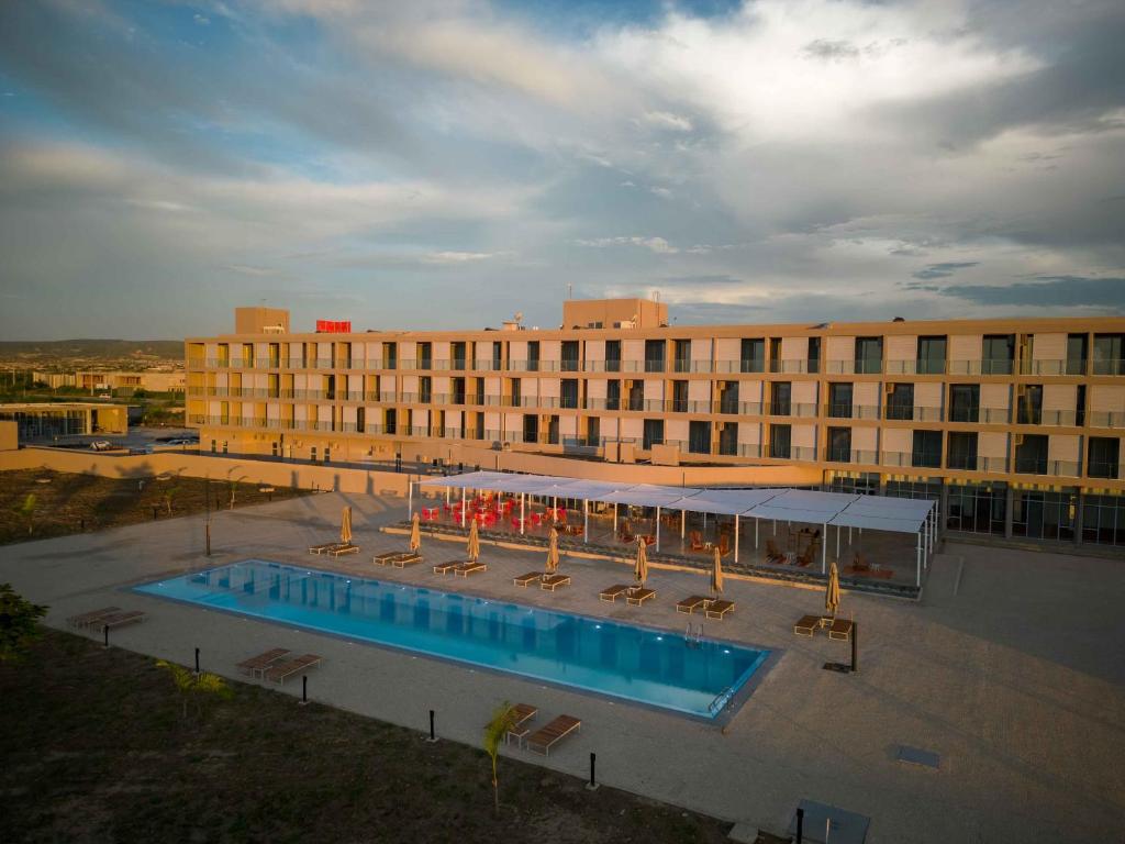 a hotel with a swimming pool in front of a building at Flow Hotel Benguela in Benguela