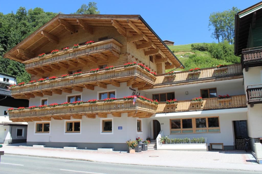 ein Gebäude mit Holzbalkonen und Blumen darauf in der Unterkunft Pension Michael in Saalbach-Hinterglemm