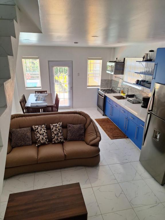 a living room with a brown couch in a kitchen at Tropical Apartments Tobago in Bethel