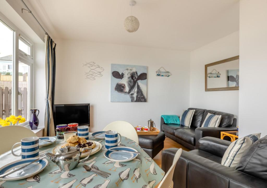 a living room with a table and a couch at Gone To The Beach - Fishcombe Cove in Brixham