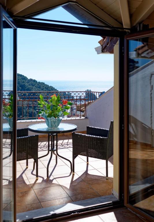 a patio with a table and chairs on a balcony at Villa Renata & Magic Suite in Parga