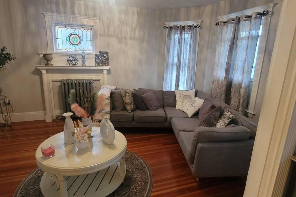 ein Wohnzimmer mit einem Sofa und einem Tisch in der Unterkunft Modern Haven ,Your Stylish Retreat in Boston