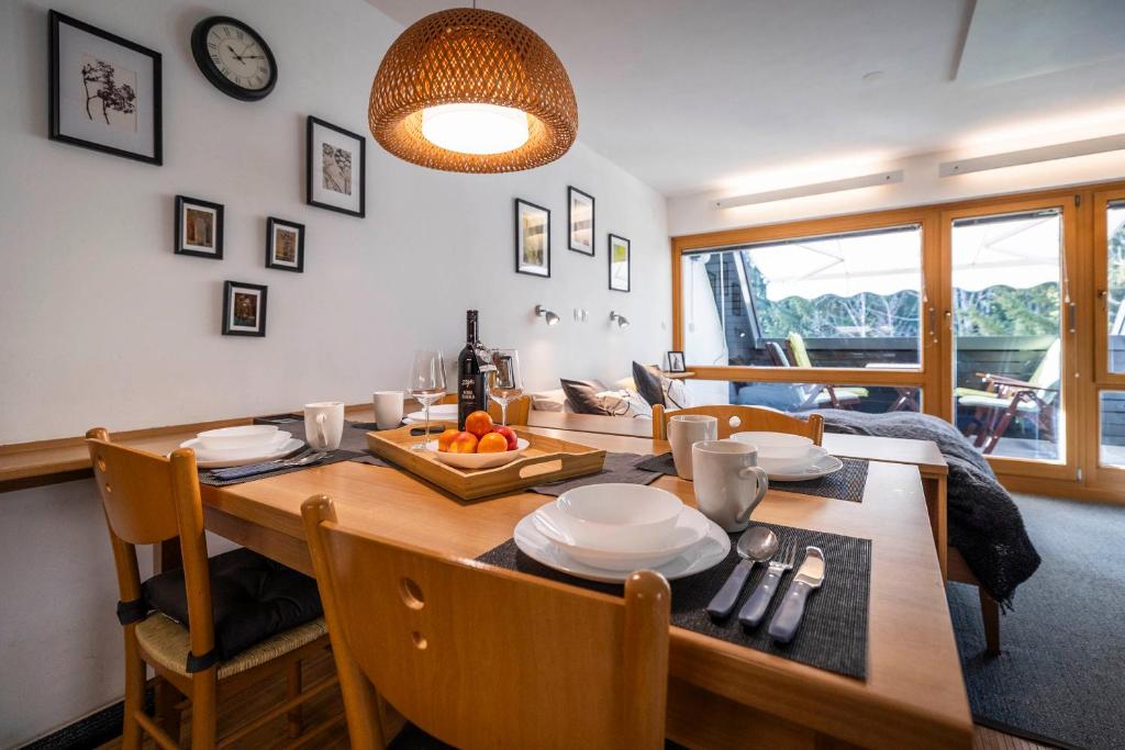 a dining room with a wooden table with a plate of fruit on it at Riversound in Kranjska Gora