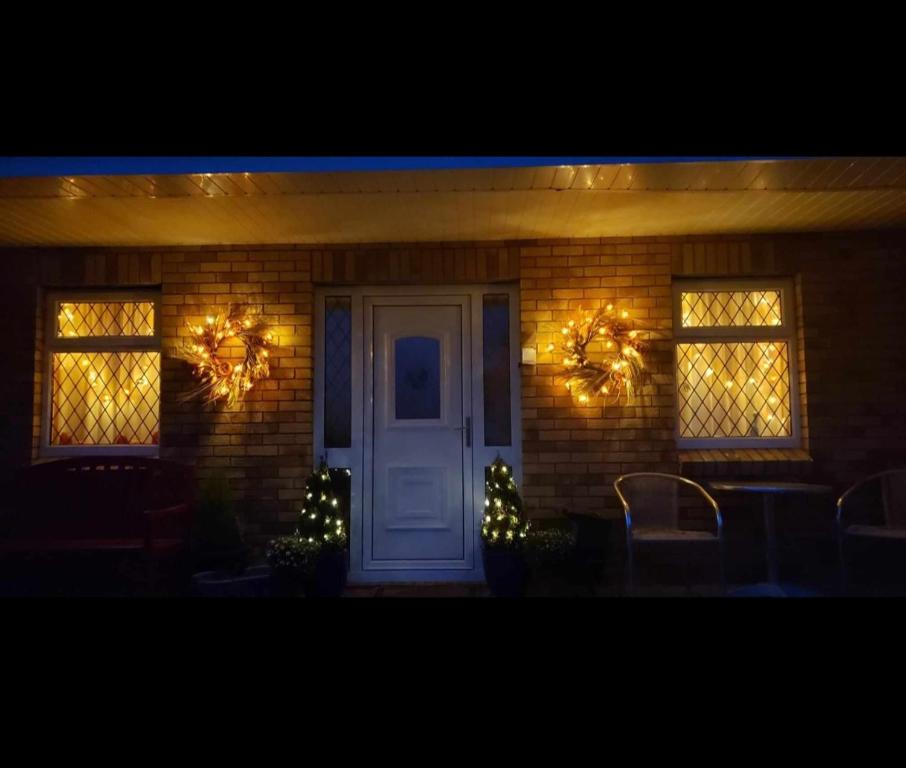 利默里克的住宿－Stay With Jack，一座配有圣诞灯和白色门的房子