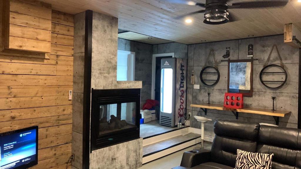 een woonkamer met een open haard en een televisie bij Gîte des étoiles in Notre-Dame-Des-Bois