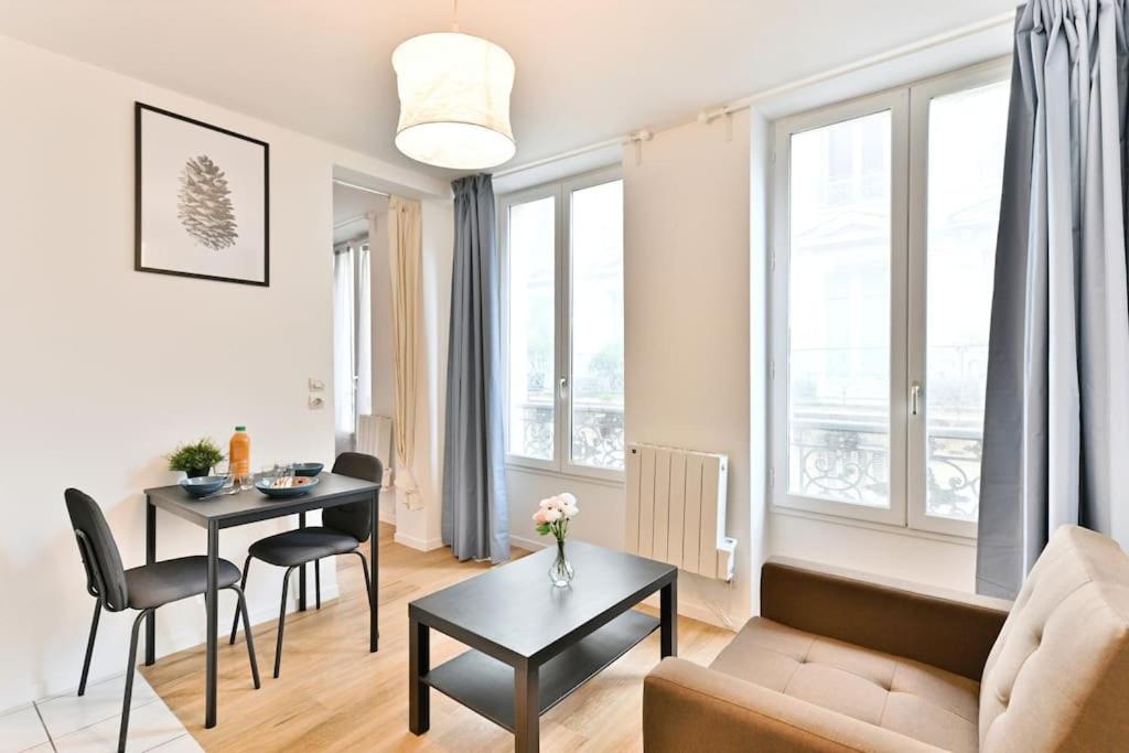 un salon avec un canapé et une table dans l'établissement Appartement proche Mairie 10ème arrondissement, à Paris