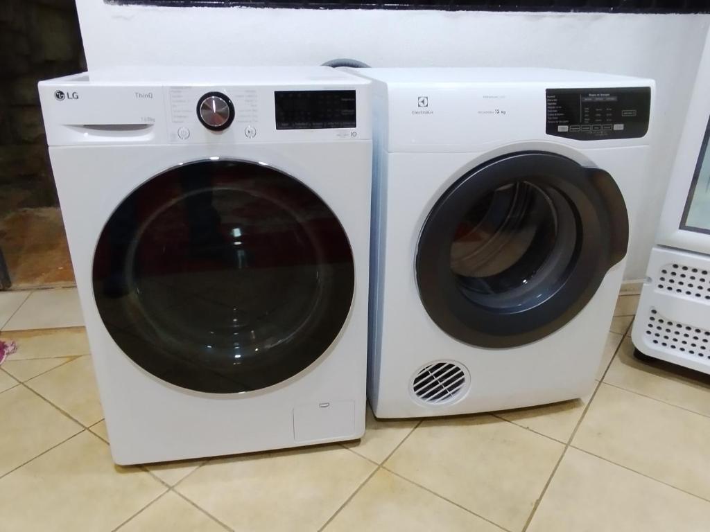 una lavadora blanca junto a una lavadora en Pousada Indi, en Ribeirão Preto