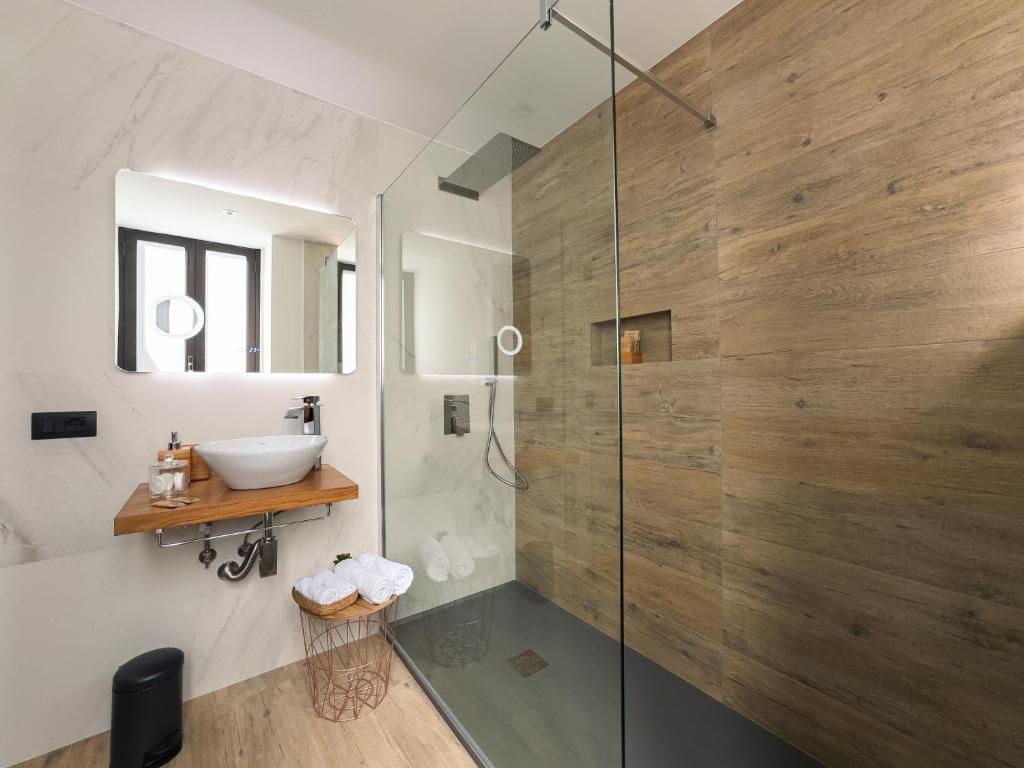 uma casa de banho com uma cabina de duche em vidro e um lavatório. em Calumidda em Catânia