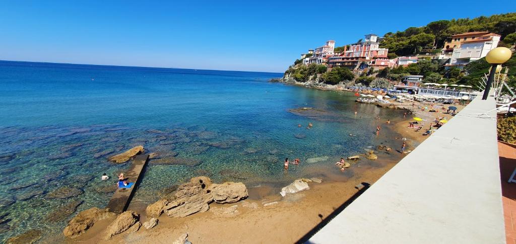 uma vista para uma praia com pessoas na água em Residence Mediterraneo - Baia del Quercetano em Castiglioncello