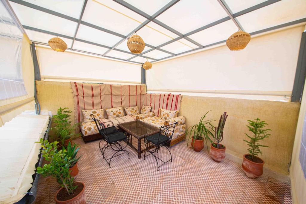 un patio con sofá, mesa y plantas en Dar houda, en Fez