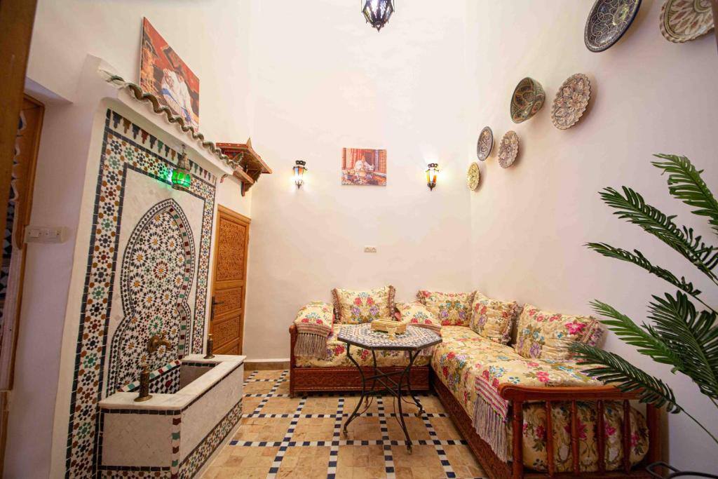 sala de estar con sofá y mesa en Dar houda, en Fez