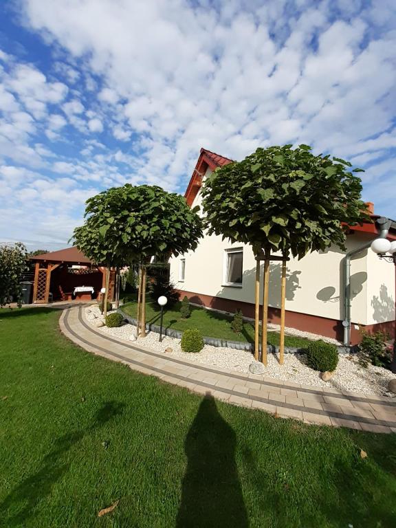 zwei Bäume in einem Hof neben einem Haus in der Unterkunft Noclegi Dobrzeń Wielki in Dobrzeń Wielki